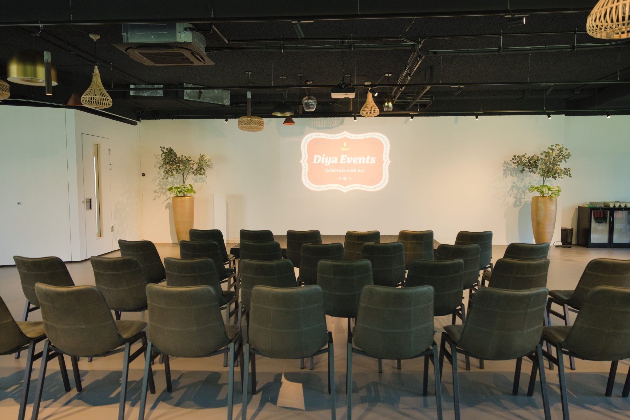 Eventzaal in theateropstelling met Diya Events op de projectiewand.